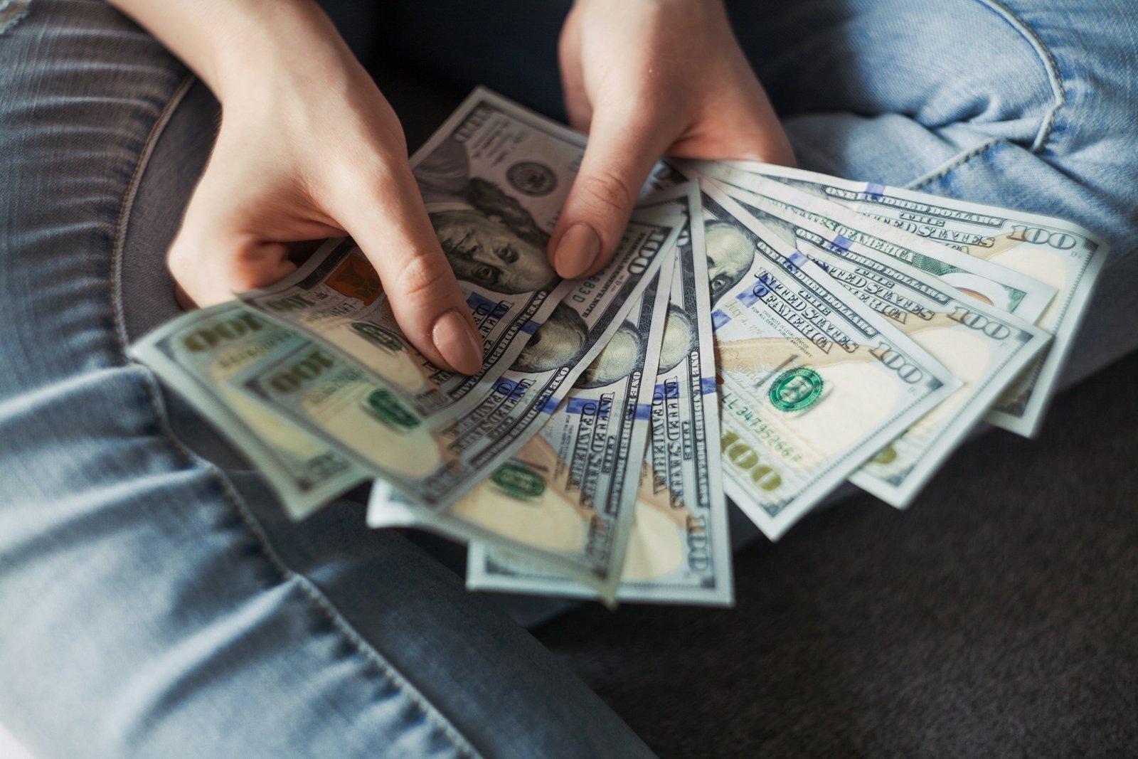 A young woman holding dollar bills | Source: Unsplash